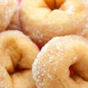 Golden soft freshly baked or deep fried ring doughnuts sprinkled with sugar for an unhealthy but tasty breakfast
