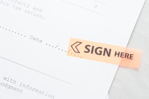 a contract document with a sign here marker