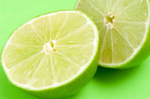 Close up view of fresh halved limes with their thin rind and tangy acidic pulp rich in vatamin c used as a flavouring in cooking